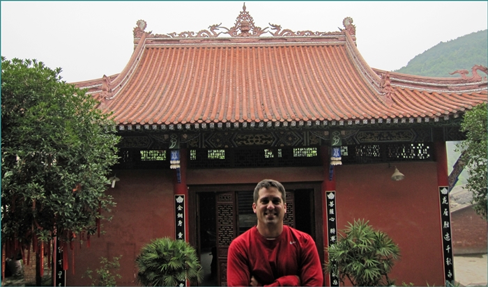 John Gunter in front of a Buddhist temple in Asia.